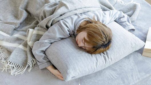 침대 위에서 엎드려 베개를 안고 깊이 잠든 모습으로, 엎드려 잘 때 얼굴이 압박되며 붓기가 심해질 수 있는 상황을 보여주는 이미지.