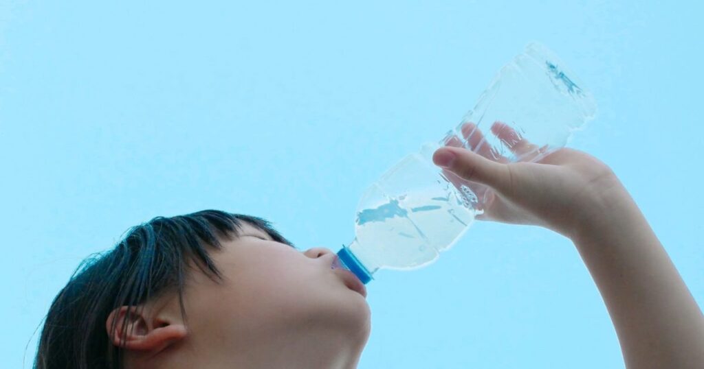 하늘을 배경으로 물을 마시는 모습으로, 수분 섭취와 몸 붓기 조절의 관계를 설명하는 데 활용되는 이미지.