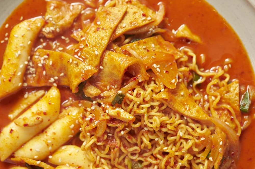 라면과 떡볶이처럼 나트륨이 많은 음식을 섭취한 장면으로, 짠 음식 섭취 후 몸이 자꾸 붓는 원인을 설명하는 이미지.